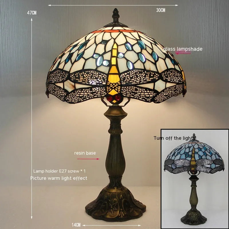 Stone Tiffany dragonfly table lamp in European retro style on a wooden table.