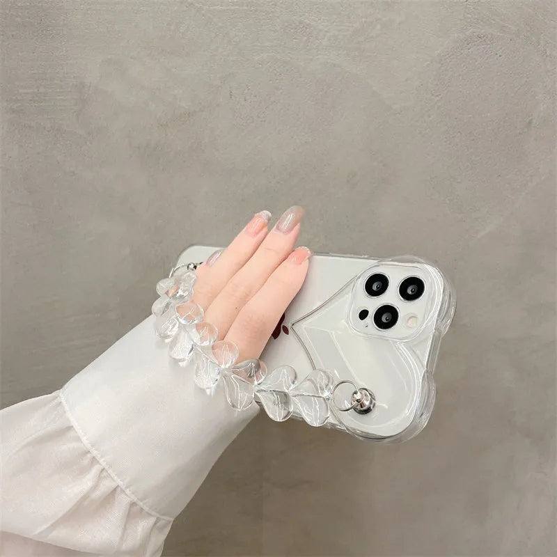 Transparent iPhone case with a love heart charm on a chain, on an iPhone.