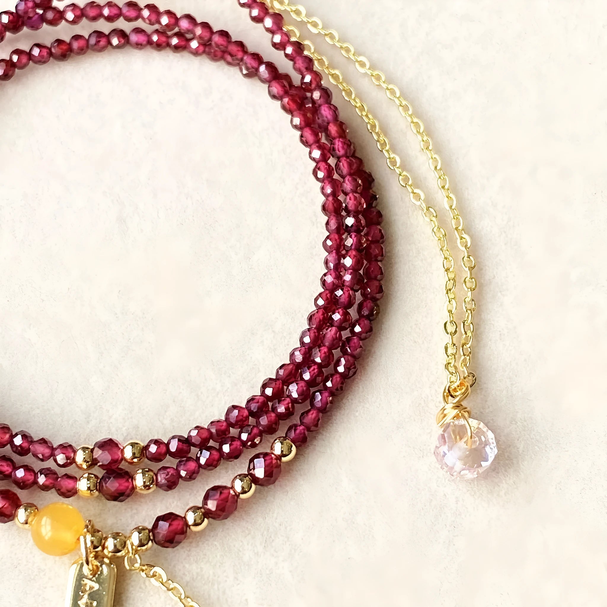Wine red garnet bracelet with three circle design showing 2.5mm cut stone beads and electroplated metal