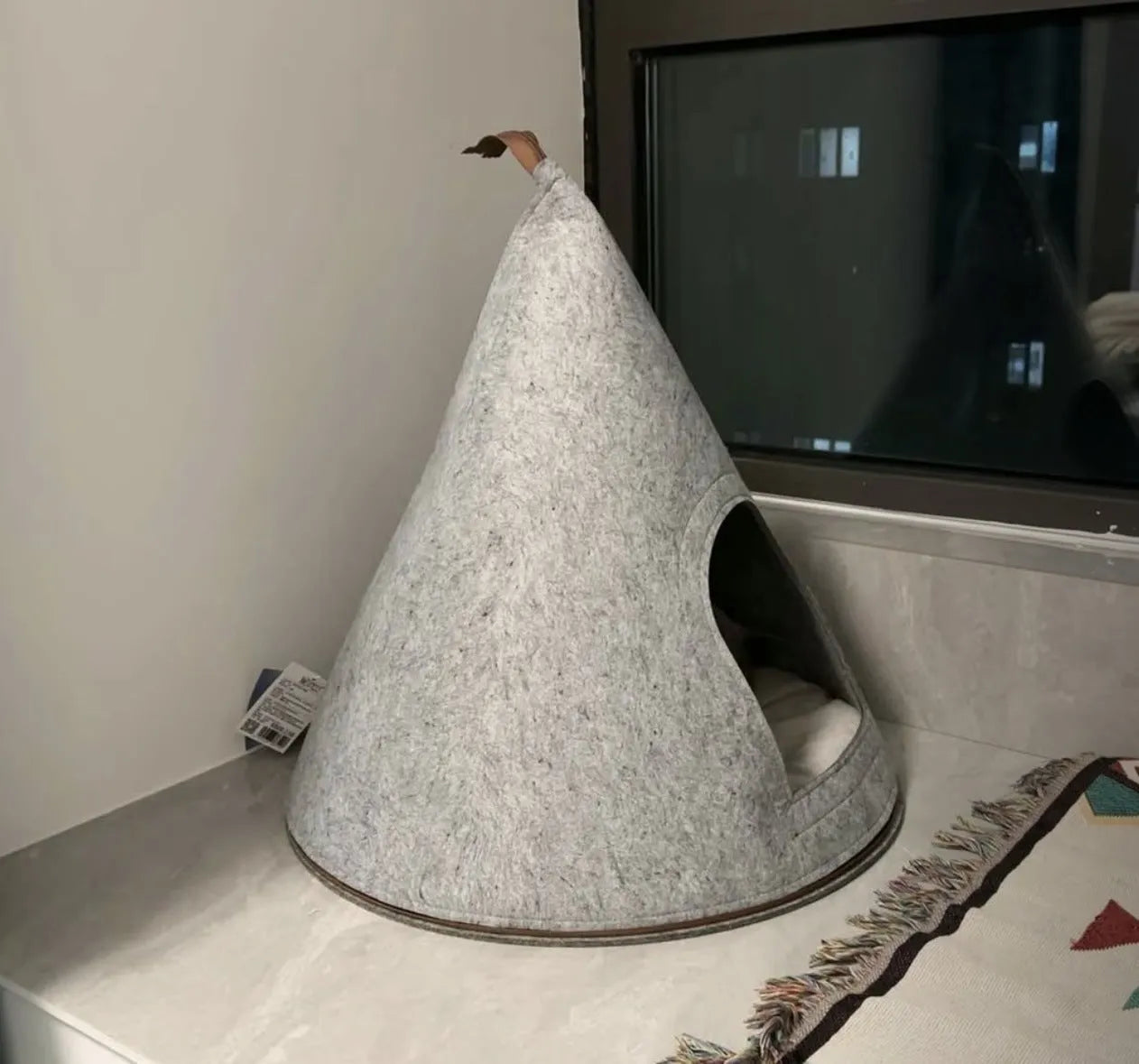 Grey handmade felt cone-shaped cat house with enclosed tent-style design