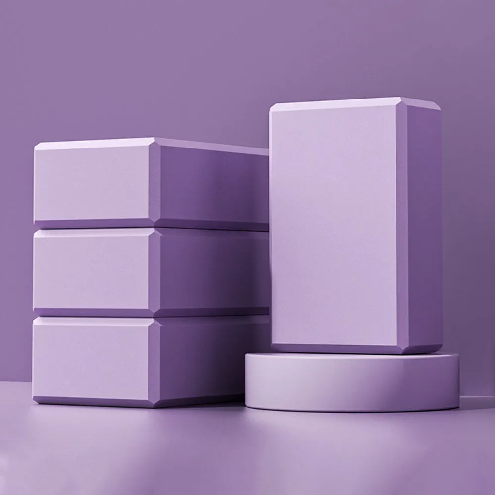 Solid colour EVA foam yoga block measuring 23cm long on a workout mat.