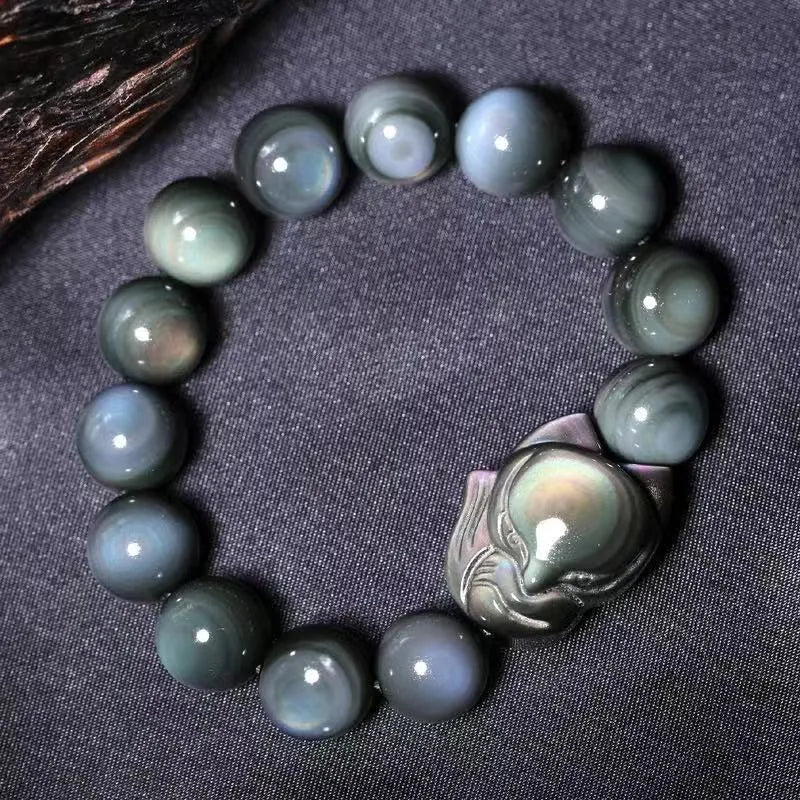 Obsidian stone bracelet with carved fox design in cartoon style, showing dark stone colouration