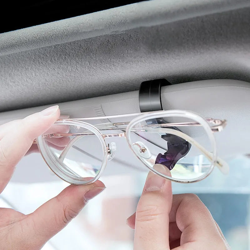Black plastic car sun visor clip for holding sunglasses, tickets and ID cards.