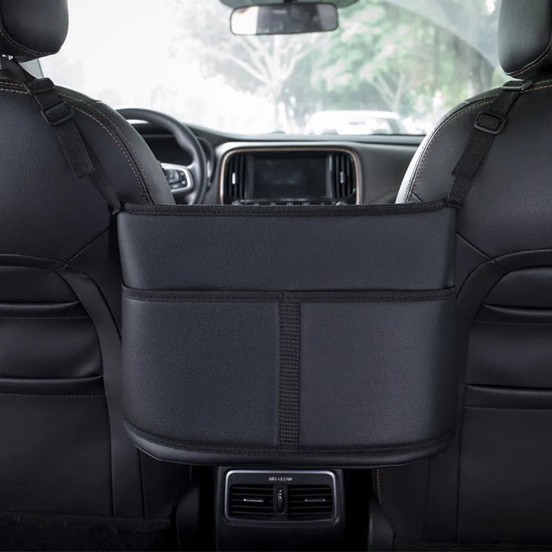 Black leather car seat hanging storage organiser for tissue boxes, shown between vehicle front seats.