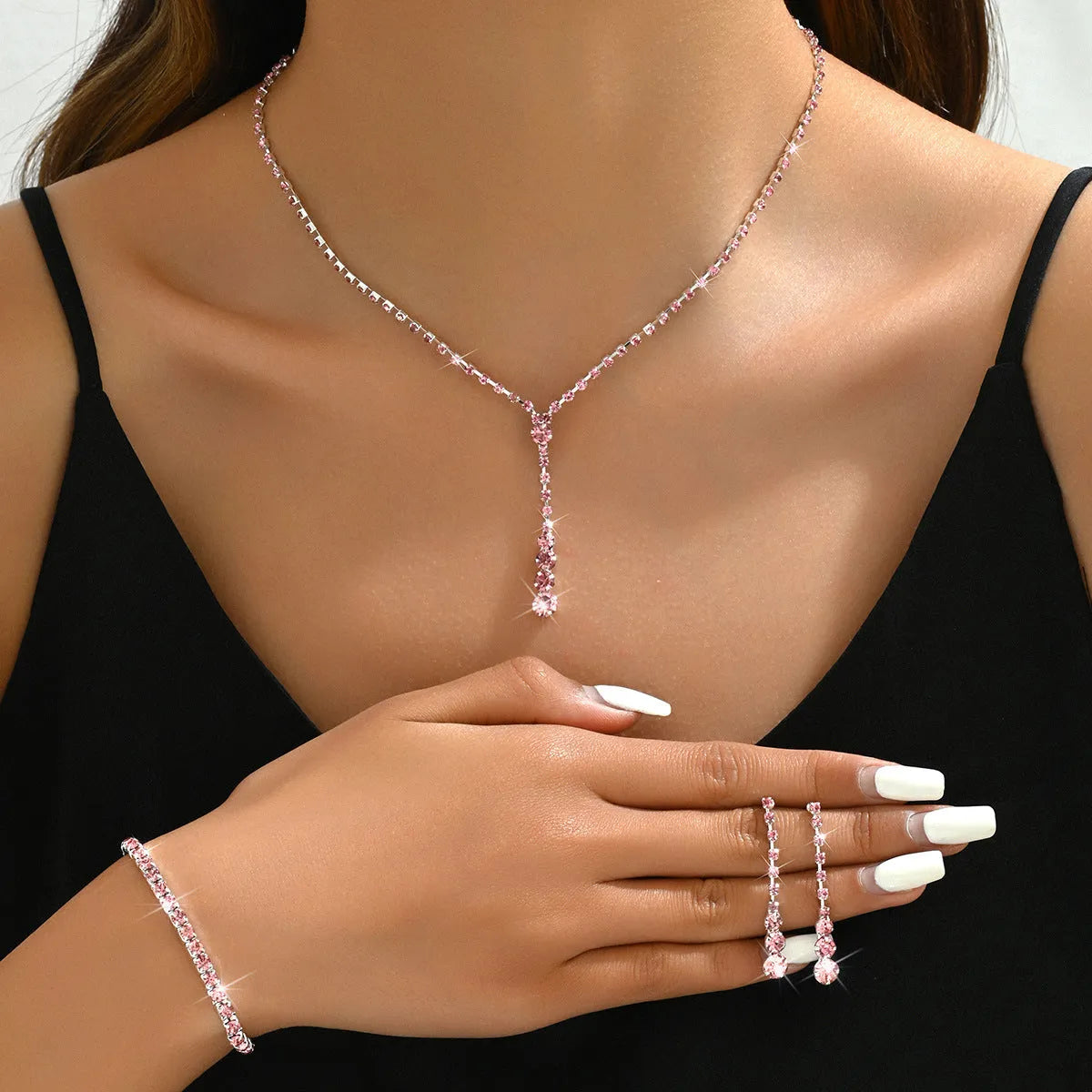 Women's rhinestone jewellery set with elastic bracelet, snake bone chain necklace, and earrings in rose gold finish.