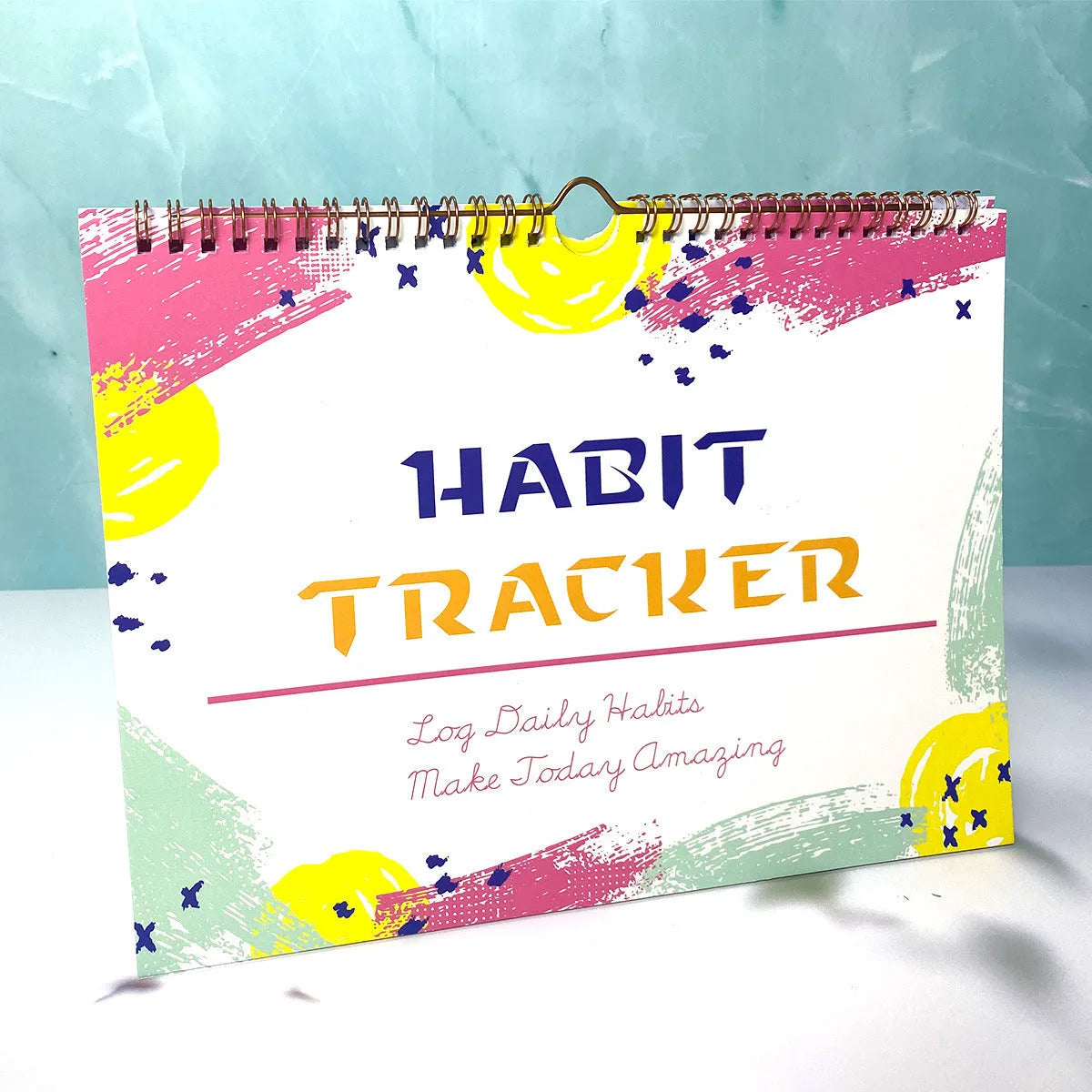 A5 habit tracking planner book open on a table, showing interior pages for schedule recording.