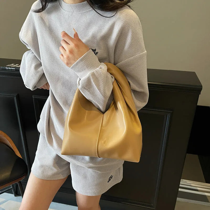 Women's casual PU leather dumpling-shaped handbag in multiple colours with internal organiser pockets.