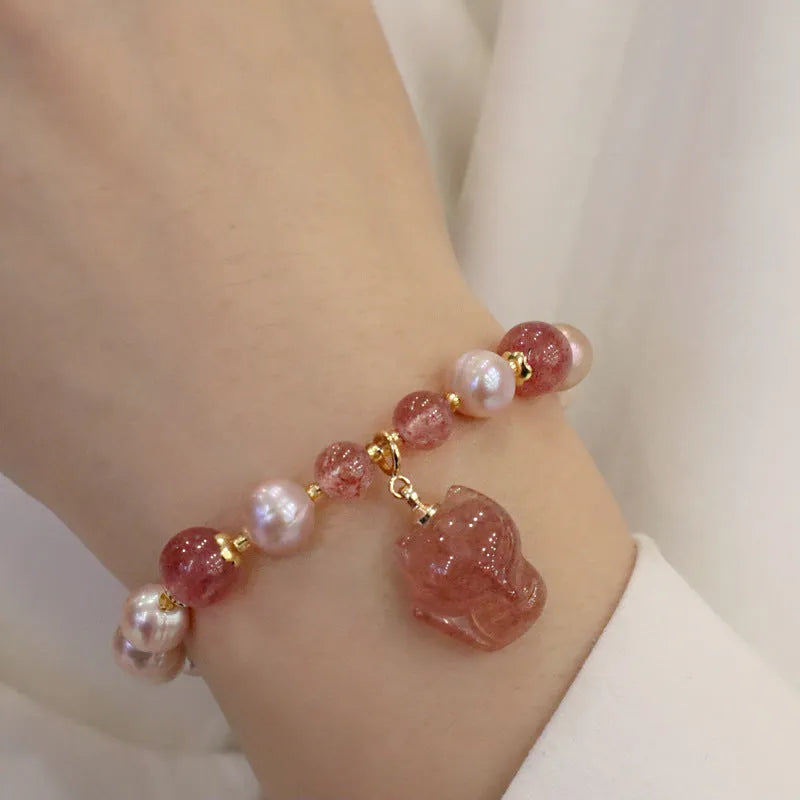 Women's light pink freshwater pearl bracelet with strawberry quartz and fox charm detailing