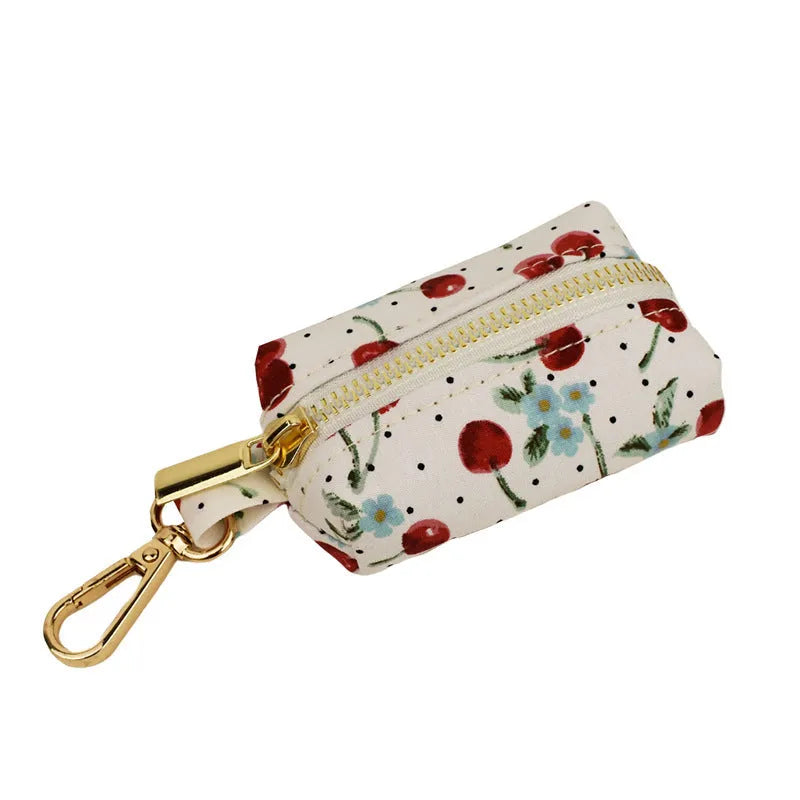 Red cherry print dog collar set with matching leash, vest, and light gold buckle