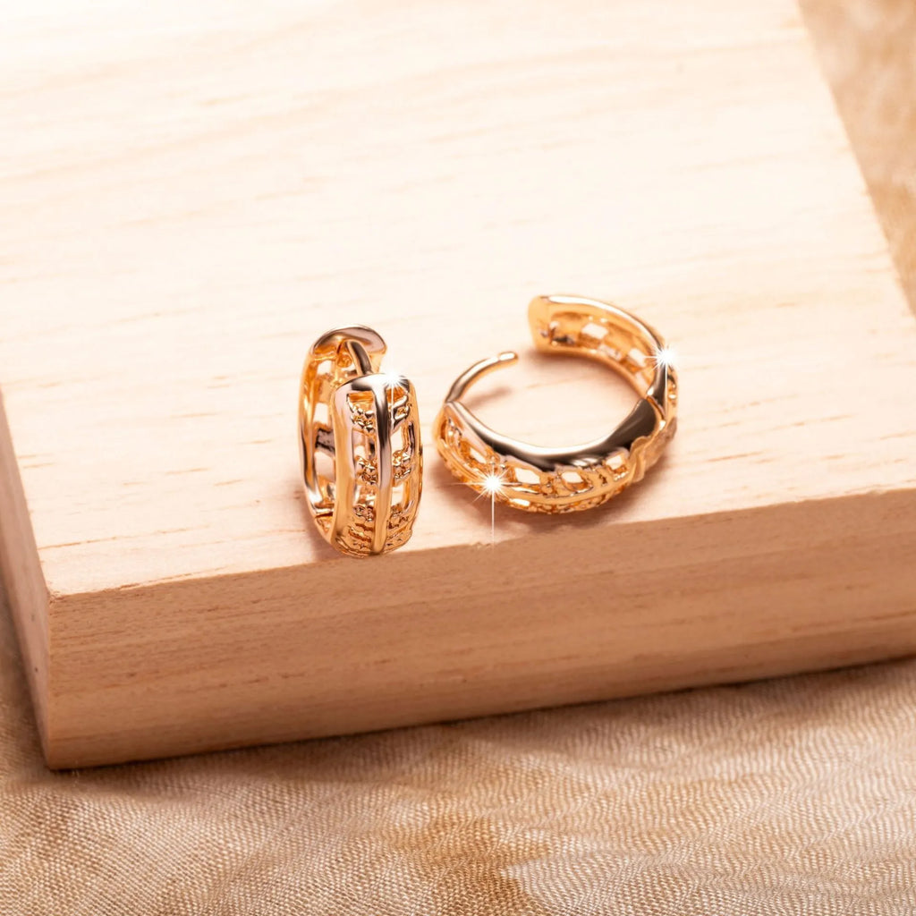 Rose gold coloured copper earrings with hollowed-out leaf and heart shapes.
