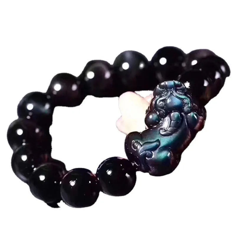 Natural eye obsidian crystal bracelet with ice colour tones and silver clasp on a wrist.