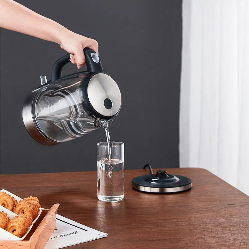 Transparent glass electric kettle with 1.7L capacity, scale window, black base and handle, and power cord on white background