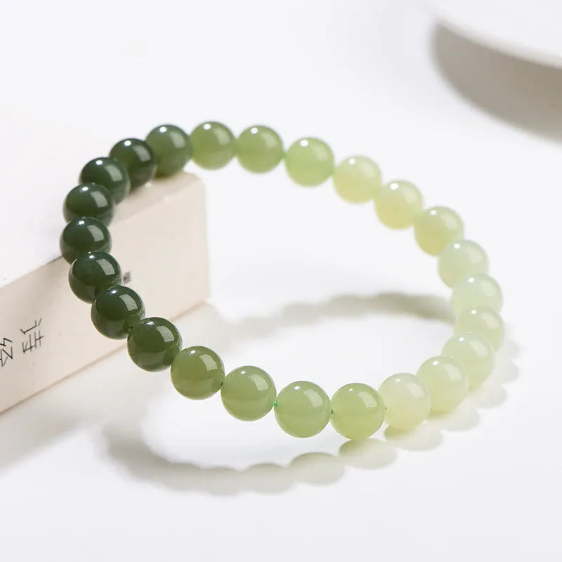 Natural gradient water Hetian jade bead bracelet showing round and barrel bead options on an adjustable string.
