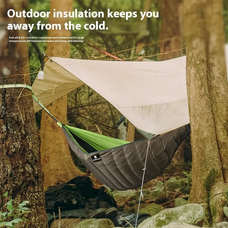 Army green thickened camping hammock sleeping bag with compression bag, shown in an outdoor setting.