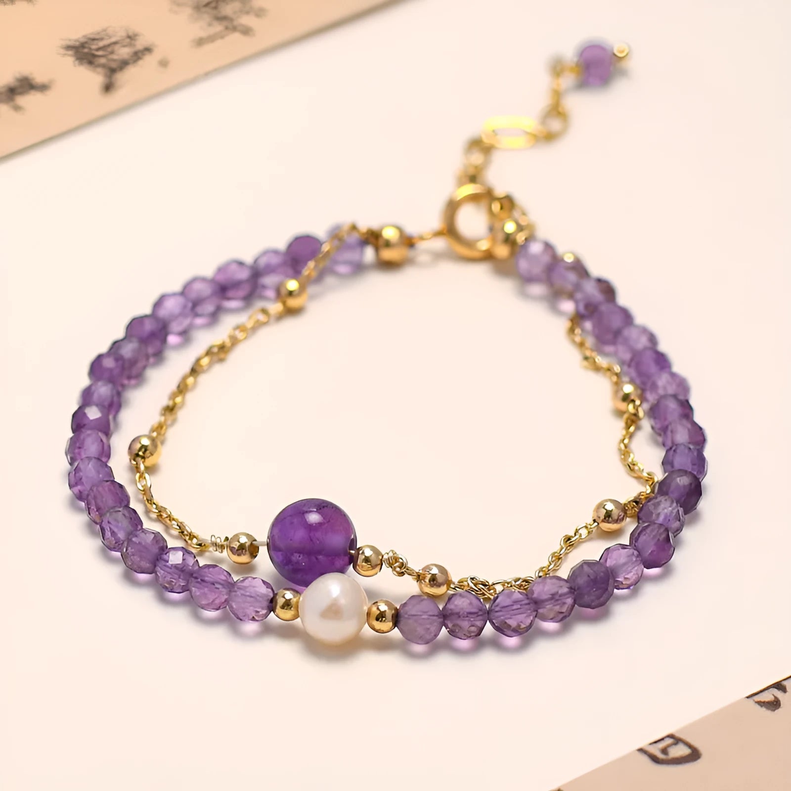 Close-up of a Chinese style women's bracelet with diamond-shaped amethyst crystals and an electroplated finish.