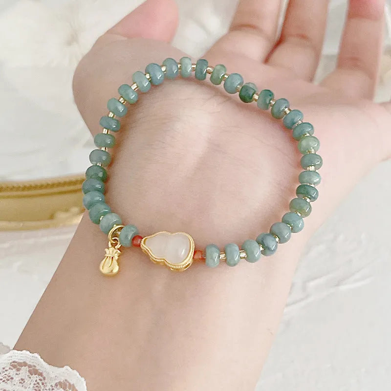Blue-toned jade bracelet with gourd and peace buckle charms and strawberry quartz accents