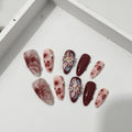Almond-coloured hand-painted artificial nails with 3D carved rose and butterfly designs, shown in short and almond shapes.