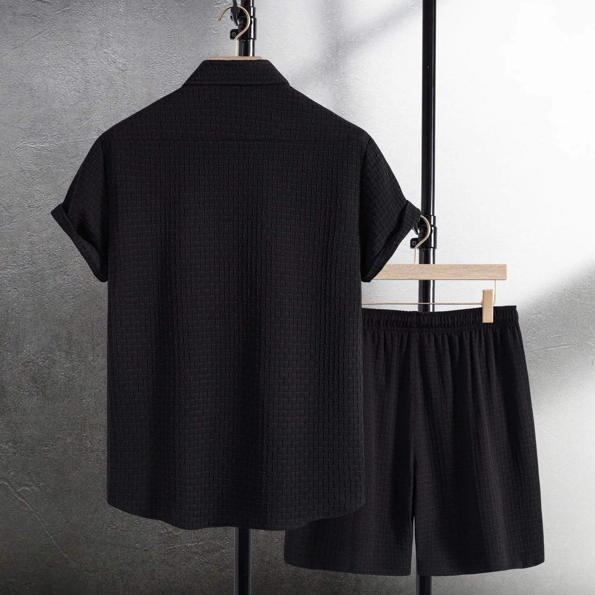 Men's black cotton blend short sleeve shirt and shorts suit set on a hanger.
