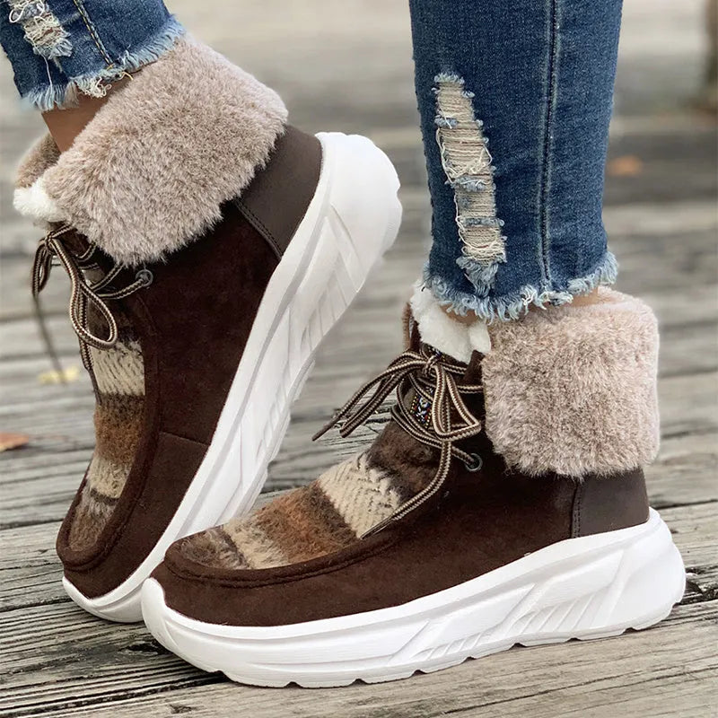 Beige women's lace-up suede mid-top snow boots with a thick sole on a winter background.