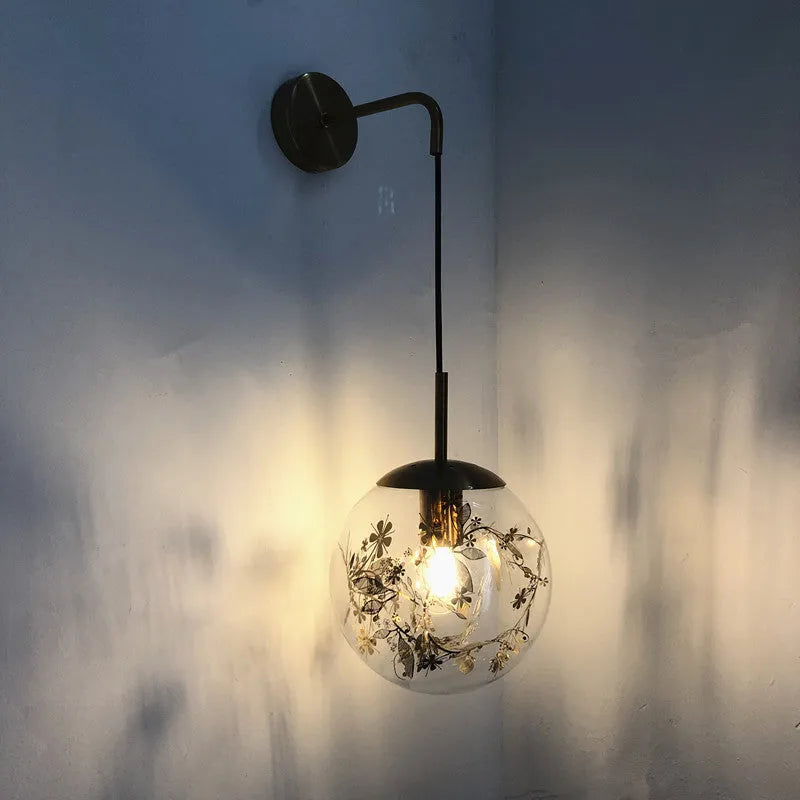 Modern glass wall lamp with golden flower finish and warm white LED light.
