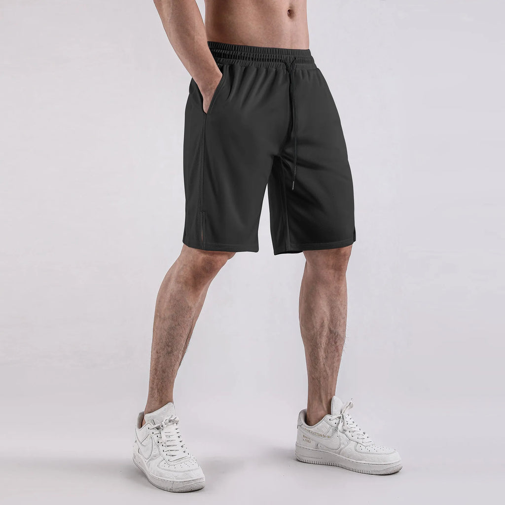 Man wearing loose-fitting black quick-dry mesh fitness shorts with an elasticated waistband.