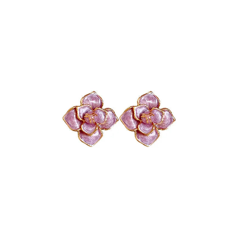 Close-up of gold plated purple oil-spot glaze flower stud earrings on a copper base.