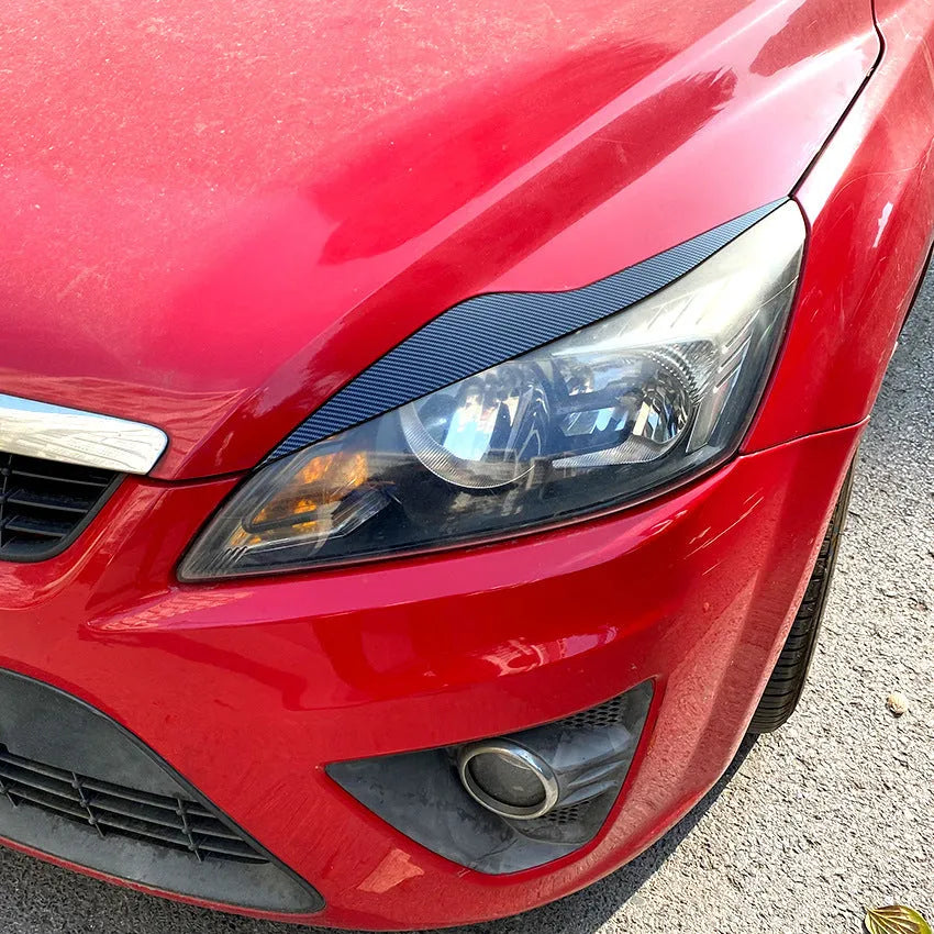 Pair of ABS plastic headlight eyebrow stickers for Ford Focus in carbon fibre pattern and piano black finish