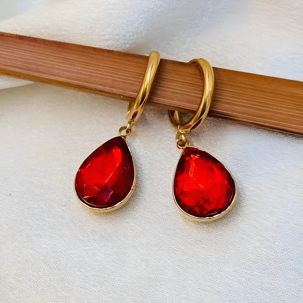 Carved geometric Saturn-shaped glass water drop earrings with copper details on a model.