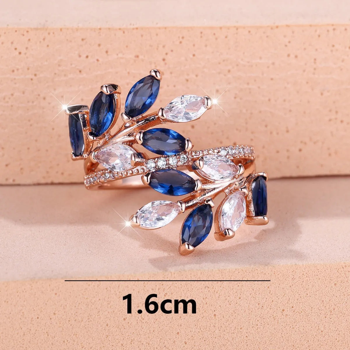 Adjustable open-ended leaf-shaped ring with zirconia stones on a copper band.