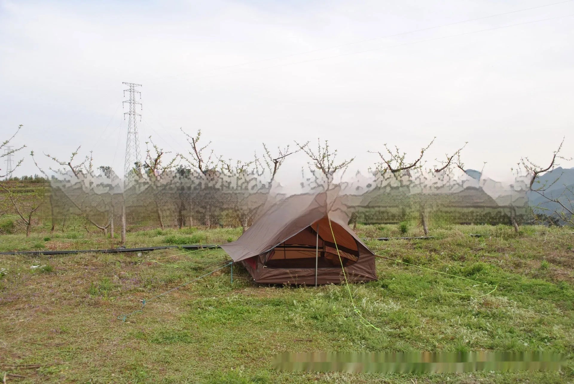 Brown A-line pole-free cabin tent pitched with hiking canes showing spacious interior dimensions