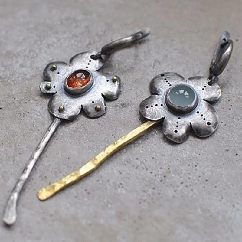 A pair of long retro earrings with asymmetric geometric flower shapes in a two-tone electroplated finish.