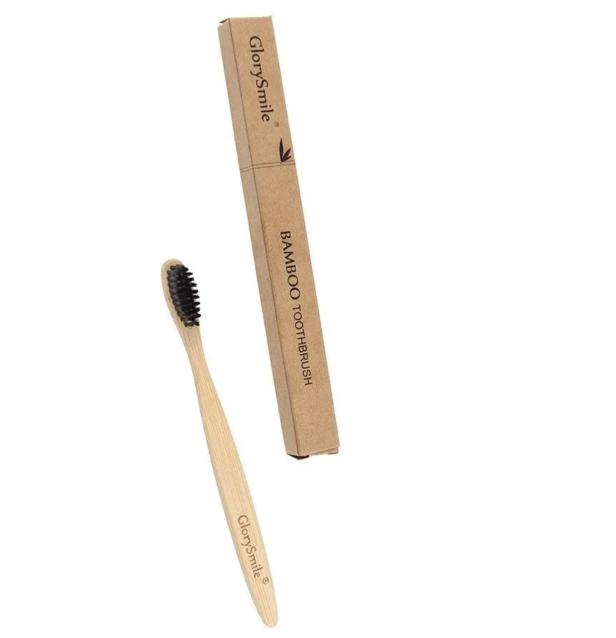 Natural pure bamboo toothbrush with black charcoal-infused bristles on a light background