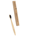 Natural pure bamboo toothbrush with black charcoal-infused bristles on a light background