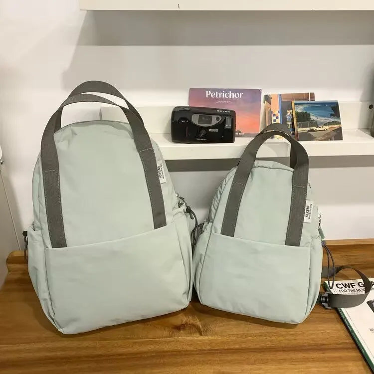 Solid colour nylon backpack with curved shoulder straps and a lock closure.