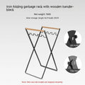 Outdoor black wrought iron garbage storage hanger with wooden handle holding bin bag