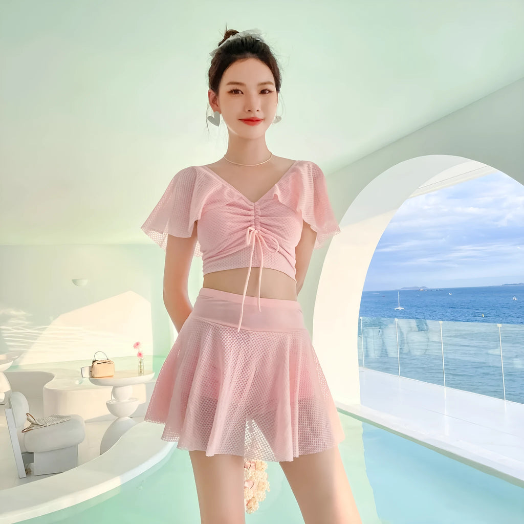 Women's solid colour two-piece swimsuit set with a top and split skirt.