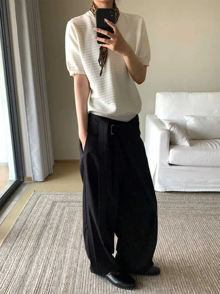 Black straight-leg trousers with a single pleat and adjustable waistband, made from a Tencel and cotton blend fabric.
