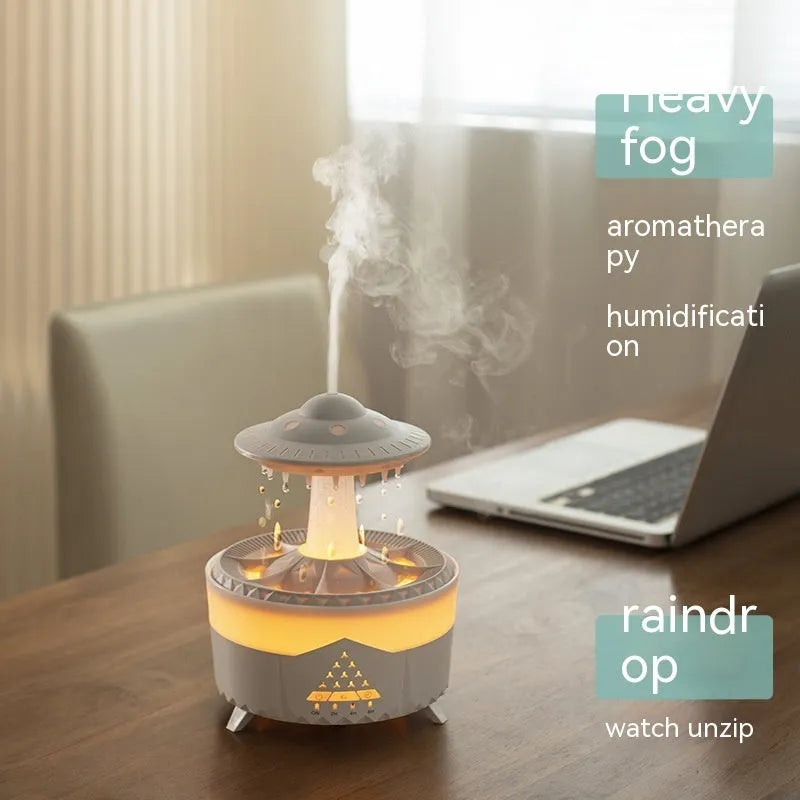 White cloud-shaped humidifier with raindrop mist and coloured night light on wooden table