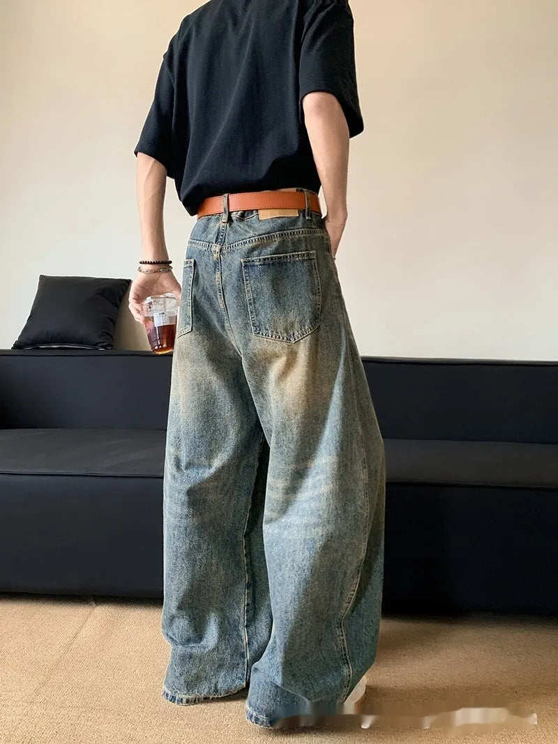 Man wearing retro blue distressed wide-leg denim jeans with machete detailing