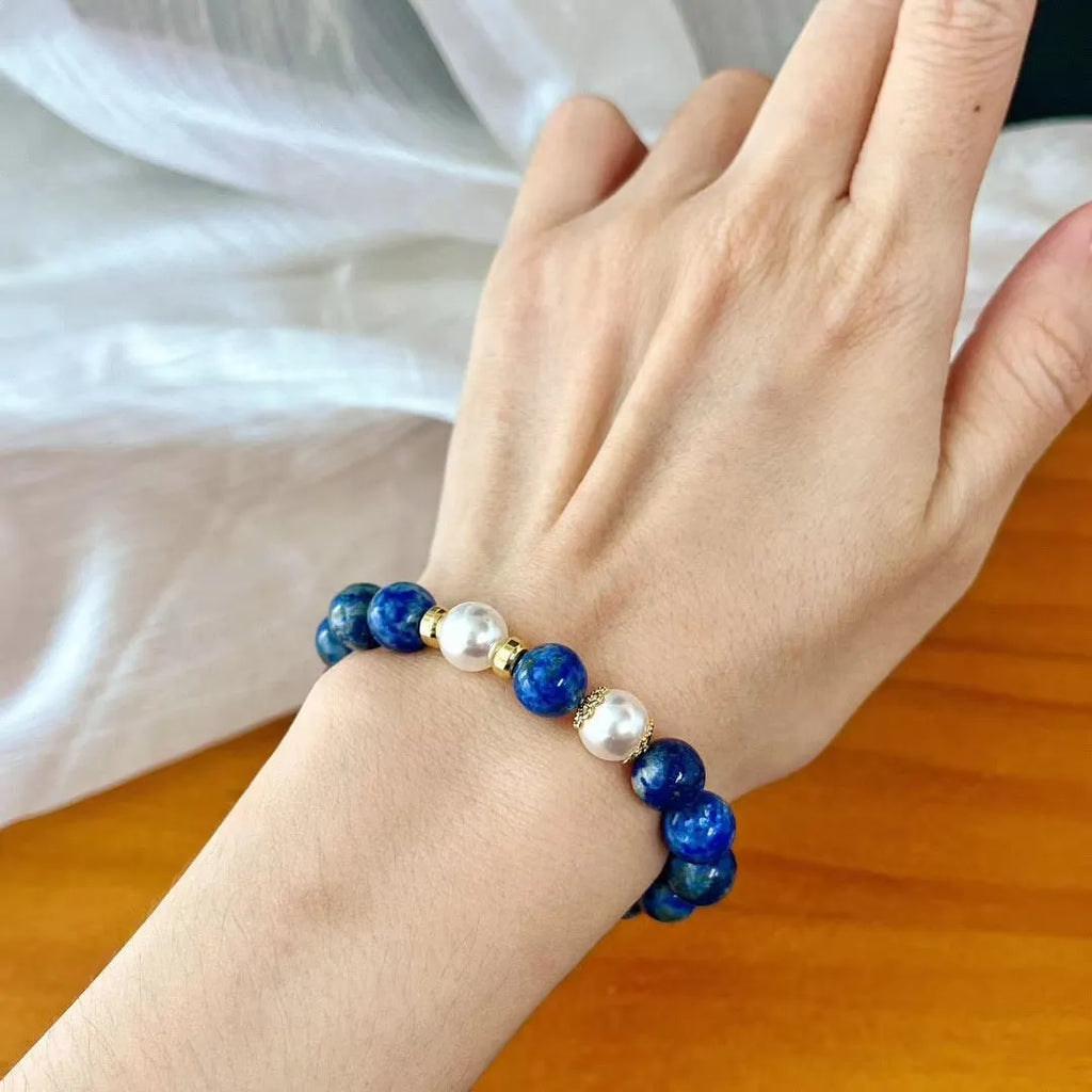 Natural green and gold lapis lazuli stone bracelet with a Chinese retro design on a wrist.