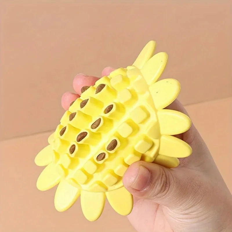 Yellow rubber sunflower dog chew toy with green stem, shown on a white background.