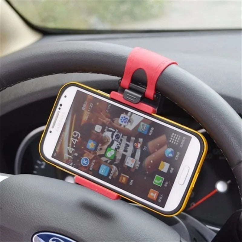 Black universal steering wheel phone holder clip mount attached to a car steering wheel.