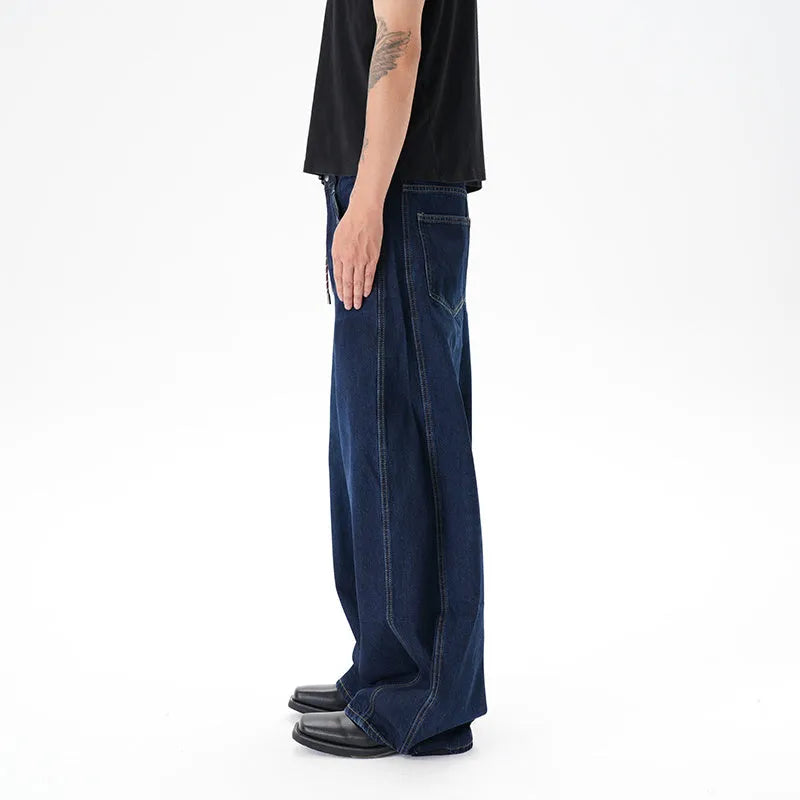 Dark blue distressed wide leg jeans with a machete cut design on a denim fabric.