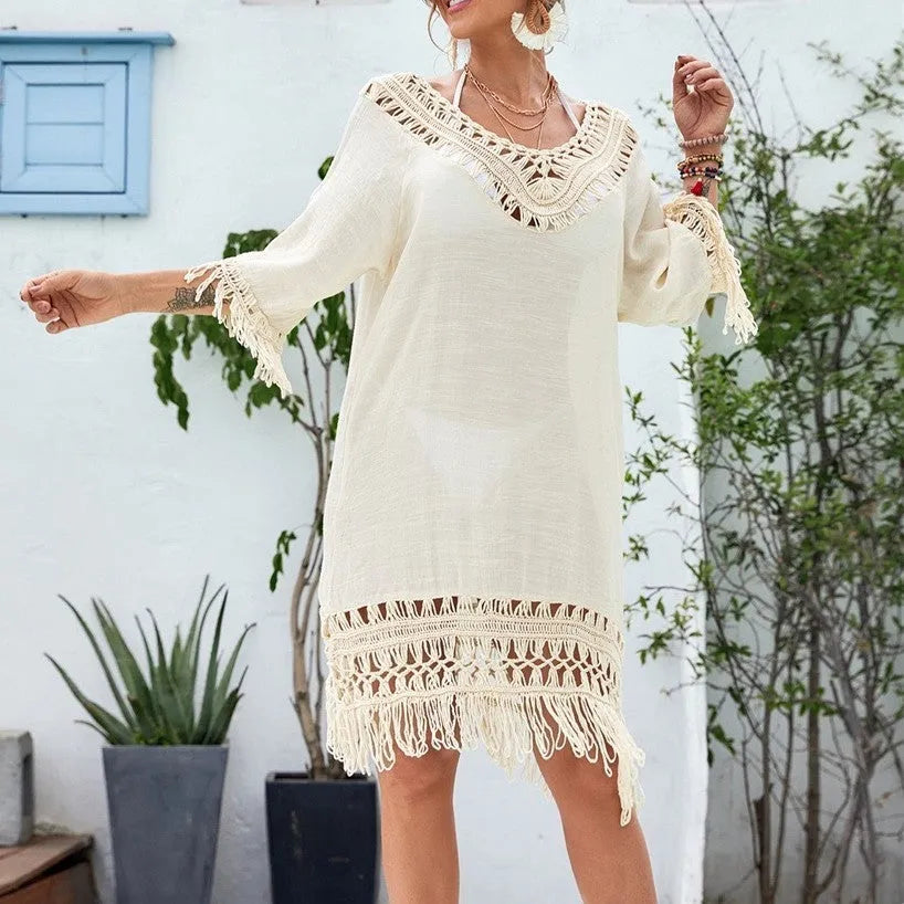 Apricot coloured crocheted patchwork beach dress on a hanger, showing mid-length skirt and half sleeves.
