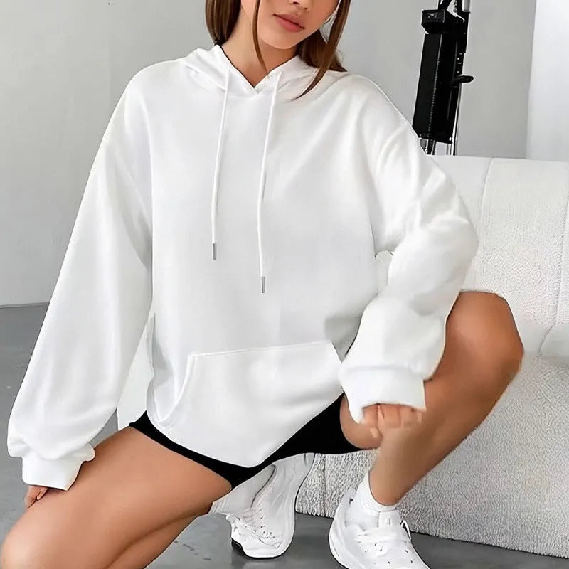 Women's loose grey sweatshirt with a front pocket and drawstring waist, worn with jeans.