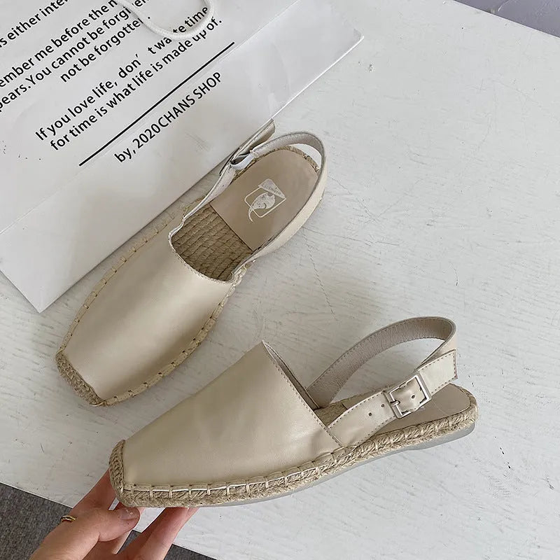 Women's beige canvas baotou flat sandals with a retro fisherman style on a plain background.