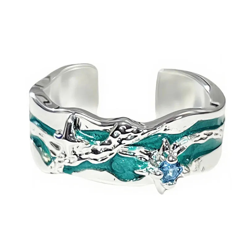 Mint green enamel asterism ring with copper base and eight-point star pattern on finger