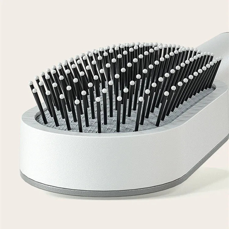 Self-cleaning hair brush with one-key button, air cushion base, and long bristles on a white background.