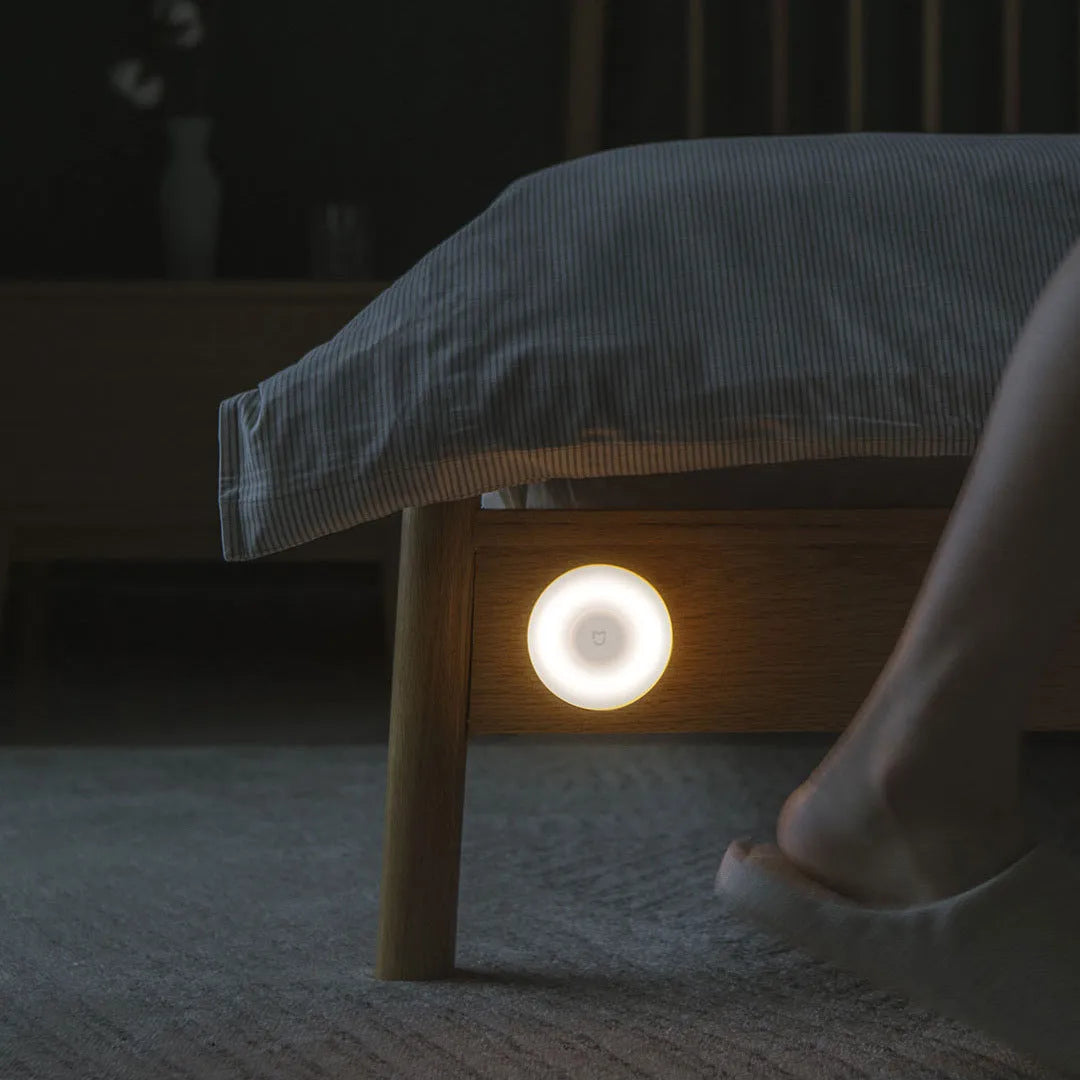 White modern bedside table lamp with sensor and Bluetooth on a wooden nightstand.