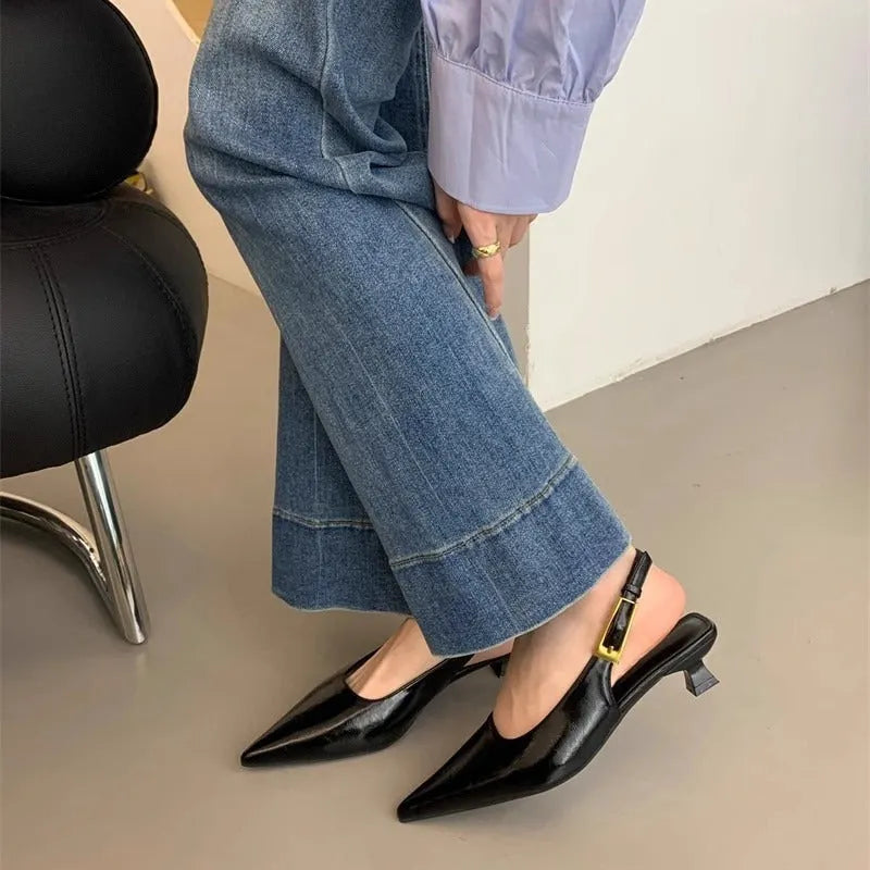 Thin low heel strap pointed leather shoes in black colour showing ankle strap and rubber sole